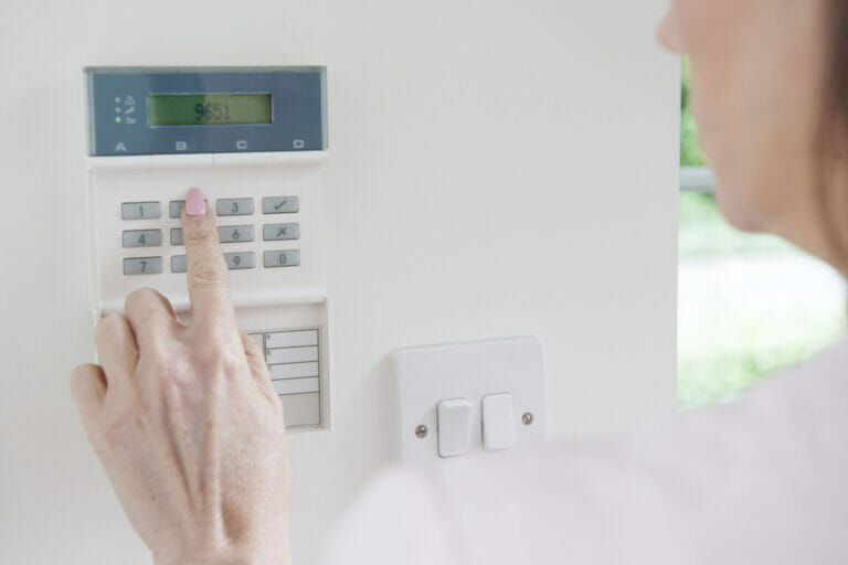 29906041 - woman setting control panel on home security system